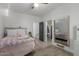 Bright bedroom with wood-look tile flooring, a ceiling fan and doorways to closets at 2634 E Tamarisk St, Gilbert, AZ 85296