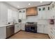 Stylish kitchen with white cabinets, brick accent wall, and stainless steel appliances, including a blue range at 2634 E Tamarisk St, Gilbert, AZ 85296