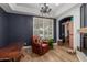 Inviting sitting room featuring a leather chair, dark blue walls, and a charming chandelier at 2634 E Tamarisk St, Gilbert, AZ 85296