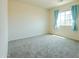 A bright bedroom with a large window, neutral walls, and carpeted floor at 2826 E Tracy Ln # 3, Phoenix, AZ 85032