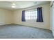 A bright bedroom with a large window, neutral walls, and carpeted floor at 2826 E Tracy Ln # 3, Phoenix, AZ 85032
