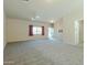 Spacious living room featuring neutral carpet, ceiling fan, and a view of the entry and hallway at 2826 E Tracy Ln # 3, Phoenix, AZ 85032