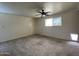 Neutral bedroom with carpet flooring, ceiling fan, a window, and a pet door at 3738 W Danbury Dr, Glendale, AZ 85308