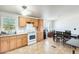 Kitchen with wooden cabinets, and white appliances open to dining area with wooden table and chairs at 3840 W Abraham Ln, Glendale, AZ 85308
