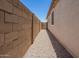 Narrow gravel side yard with block fence for privacy at 40470 W Agave Rd, Maricopa, AZ 85138