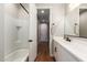 Bathroom featuring a bathtub, quartz countertop, and a view down the hallway at 40470 W Agave Rd, Maricopa, AZ 85138