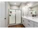 Bright bathroom featuring double sinks, quartz countertop, and a large glass shower at 40470 W Agave Rd, Maricopa, AZ 85138