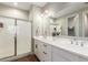 Bright bathroom featuring double sinks, quartz countertop, and large glass shower at 40470 W Agave Rd, Maricopa, AZ 85138