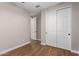 Neutral bedroom featuring sliding door closet, hardwood floors, and minimal design at 40470 W Agave Rd, Maricopa, AZ 85138