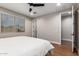 Comfortable bedroom with a ceiling fan, window with blinds, and a view of the hallway at 40470 W Agave Rd, Maricopa, AZ 85138