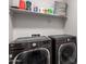 The Laundry room features a front load washer and dryer and a shelf for storage at 40470 W Agave Rd, Maricopa, AZ 85138