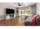 Bright living room with wood floors, ceiling fan, and sliding glass doors to the backyard patio at 40470 W Agave Rd, Maricopa, AZ 85138