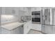 Modern kitchen with stainless steel appliances, white cabinets, quartz countertops, and tile flooring at 4200 N Miller Rd # 325, Scottsdale, AZ 85251