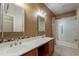 Bathroom featuring a double sink vanity with granite counters and a glass enclosed shower at 440 S Val Vista Dr # 11, Mesa, AZ 85204