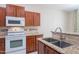 Cozy kitchen featuring wooden cabinetry, white appliances, and a convenient breakfast bar for casual dining at 440 S Val Vista Dr # 11, Mesa, AZ 85204