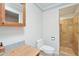 Well-lit bathroom featuring a toilet, vanity with basin, mirror and a tiled shower at 4800 N 68Th St # 357, Scottsdale, AZ 85251