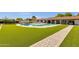 Spacious backyard featuring artificial turf, a pool, and covered patios, ideal for outdoor entertaining at 5112 E Cholla St, Scottsdale, AZ 85254