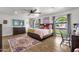 Bright bedroom with wood floors, ceiling fan, colorful rug, and large windows providing ample natural light at 5112 E Cholla St, Scottsdale, AZ 85254