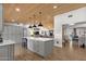 Open-concept kitchen with large island, pendant lighting, and wood-look tile floors at 5112 E Cholla St, Scottsdale, AZ 85254