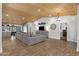 Open-concept living area featuring wood-look tile floors, a ceiling fan, and access to the kitchen at 5112 E Cholla St, Scottsdale, AZ 85254