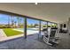 Spacious covered patio with rocking chairs overlooks a pool, an artificial lawn, and tropical landscaping at 5112 E Cholla St, Scottsdale, AZ 85254