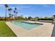 Clear blue pool with tanning ledge, surrounded by lush green turf and palm trees at 5112 E Cholla St, Scottsdale, AZ 85254