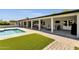 A covered patio with outdoor seating overlooks the home's private pool and artificial turf yard at 5112 E Cholla St, Scottsdale, AZ 85254