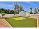 Backyard with putting green and storage shed surrounded by desert landscaping at 5827 E Larkspur Dr, Scottsdale, AZ 85254