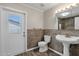 Bathroom featuring tile accents, pedestal sink, and a door with window view at 5827 E Larkspur Dr, Scottsdale, AZ 85254