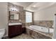 Bathroom features a soaking tub with tiled surround and a vanity sink with dark wood cabinetry at 5827 E Larkspur Dr, Scottsdale, AZ 85254