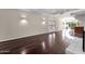 Open living room with hardwood floors, featuring stylish wall sconces and a view into the kitchen area at 5827 E Larkspur Dr, Scottsdale, AZ 85254