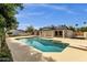 Beautiful backyard with pool, grassy area and exterior house view under a bright blue sky at 5827 E Larkspur Dr, Scottsdale, AZ 85254