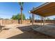 Large backyard featuring a covered patio, tall palm trees, and a wood fence at 6139 N 31St Dr, Phoenix, AZ 85017