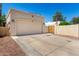Beige garage with a concrete driveway complemented by a wooden gate and tan painted walls at 630 E Jensen St # 154, Mesa, AZ 85203
