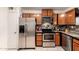 Modern kitchen featuring stainless steel appliances, wooden cabinets, and white tile floors at 630 E Jensen St # 154, Mesa, AZ 85203