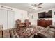 Cozy living room featuring hardwood furnishings, a ceiling fan, carpeted flooring, and a large television at 630 E Jensen St # 154, Mesa, AZ 85203