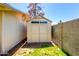 A garden shed with double doors provides ample storage space in the backyard, nestled beside a textured wall at 630 E Jensen St # 154, Mesa, AZ 85203