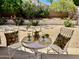 Landscaped backyard patio with a table and chairs for outdoor relaxation and enjoyment at 6626 W Monona Dr, Glendale, AZ 85308
