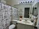 Cozy bathroom with an ornate shower curtain, vanity, and a decorative mirror at 6626 W Monona Dr, Glendale, AZ 85308
