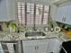 Close up on the kitchen sink featuring granite countertops, white cabinets, and stainless faucet at 6626 W Monona Dr, Glendale, AZ 85308
