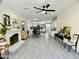 Open concept living room with fireplace flows into kitchen, featuring tile floors and modern ceiling fan at 6626 W Monona Dr, Glendale, AZ 85308