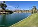 Scenic pond view features palm trees, rolling green hills, and beautiful blue skies at 6626 W Monona Dr, Glendale, AZ 85308