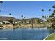 Picturesque view of golf course, pond, and palm trees under a bright blue sky at 6626 W Monona Dr, Glendale, AZ 85308