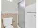 Bathroom featuring tile floors, decorative border, a glass shower door, and toilet at 6837 S Roosevelt St, Tempe, AZ 85283
