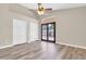 Bright bedroom featuring wood-look floors, ceiling fan, and sliding door access to the outdoor space at 6837 S Roosevelt St, Tempe, AZ 85283
