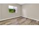 Empty bedroom showcasing hardwood floors, baseboards, and a window providing natural light at 6837 S Roosevelt St, Tempe, AZ 85283