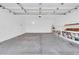 Spacious garage with a water heater, storage shelving, and concrete flooring at 6837 S Roosevelt St, Tempe, AZ 85283