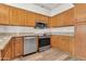 Modern kitchen features wooden cabinets, granite countertops, and stainless steel oven and dishwasher at 6837 S Roosevelt St, Tempe, AZ 85283