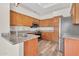 Bright kitchen features wooden cabinets, granite countertops, stainless steel appliances, and wood-look floors at 6837 S Roosevelt St, Tempe, AZ 85283