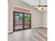 Bright room featuring wood floors, vaulted ceilings, and wooden French doors to the backyard at 6837 S Roosevelt St, Tempe, AZ 85283